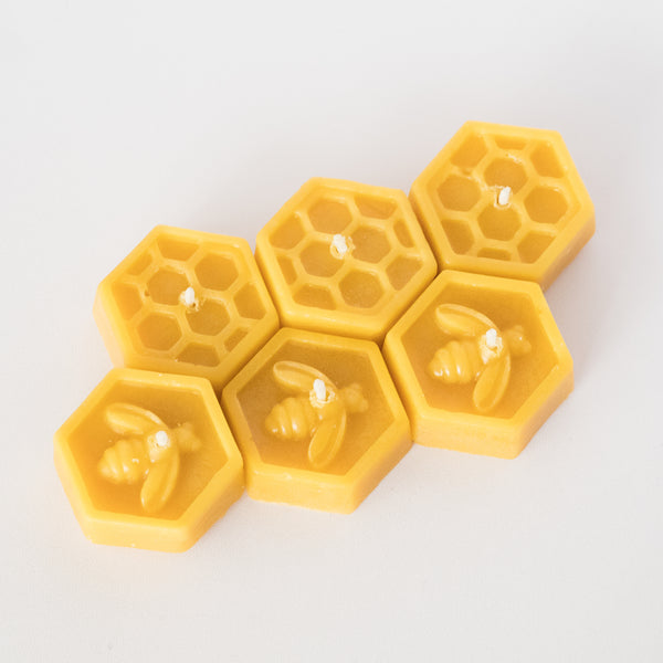 6 beeswax tealight candles with bee & honeycomb design on white background