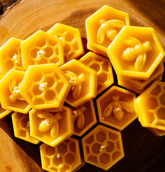 pile of beeswax tealight candles with bee and honeycomb design